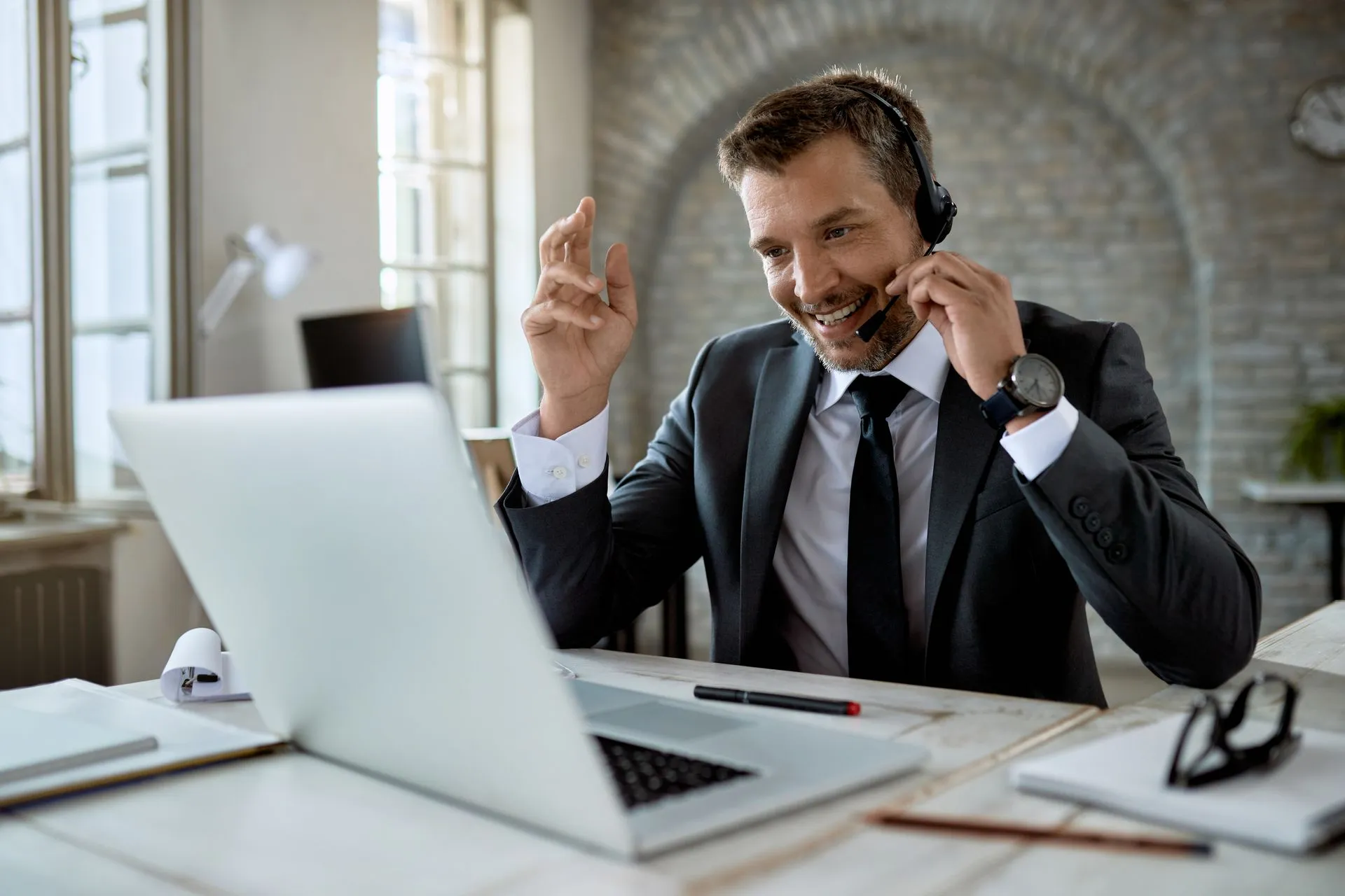 Businessman wearing a headset on a VoIP call at his laptop